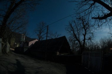 Gece sessiz köyde dolunay var. Ay ışığı altındaki dağ köyünün güzel gece manzarası. Azerbaycan doğası. Uzun pozlu çekim