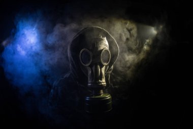 Çevre felaketi. Karanlık bir arka planda gaz maskeli kıyamet sonrası hayatta kalan biri. Gaz maskesi takan bir adamın dramatik portresi. Radyasyon koruması demek. Seçici odak