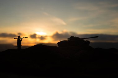 Askeri askerler bazuka ve roketatarlı siluetler. Savaş Konsepti. Askeri siluetler savaş sahnesinde sisli gökyüzü arka planında, gün batımında RPG ile Mojahed.