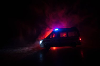 Ambulans arabasıyla Corona virüsü konsepti. Corona virüsünü önlemek için tedbir amaçlı önlemler için evde kal. Ambülans arabası koyu sisli arka planda. Yaratıcı sanat dekorasyonu. Seçici odak