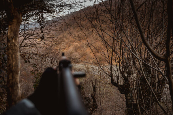 Стрелок целился в цель из автомата. Опасный бандитский пистолет. Специальный солдат во время военной операции горная дорога. Селективный фокус
