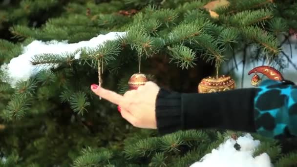 Una mujer cuelga las decoraciones del árbol de Navidad — Vídeo de stock