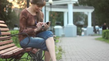 Kız telefon ile bankta