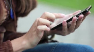 Kız telefon ile bankta