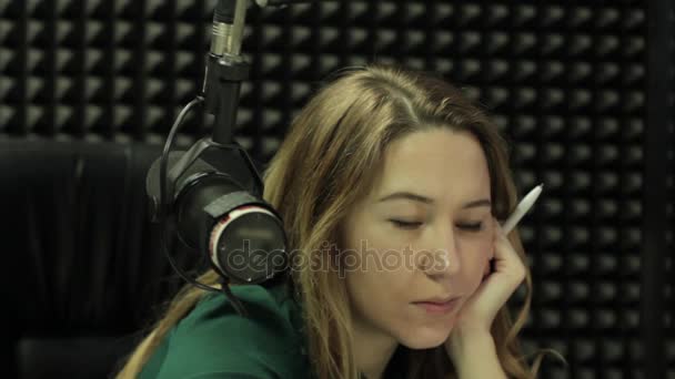 Девушка сидит за микрофоном — стоковое видео