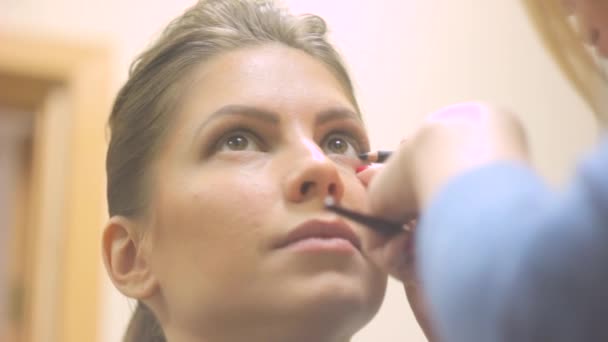 Maquillaje artista pinta los ojos de la mujer — Vídeos de Stock