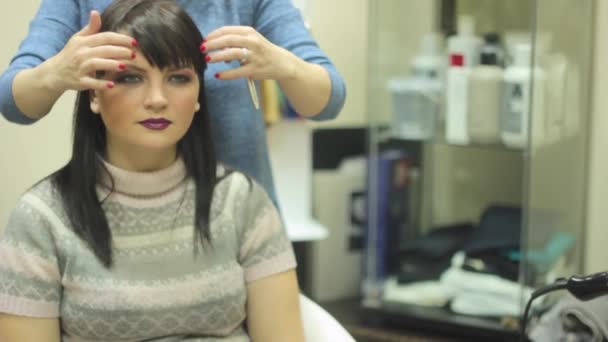 Женщина сидит у парикмахера — стоковое видео