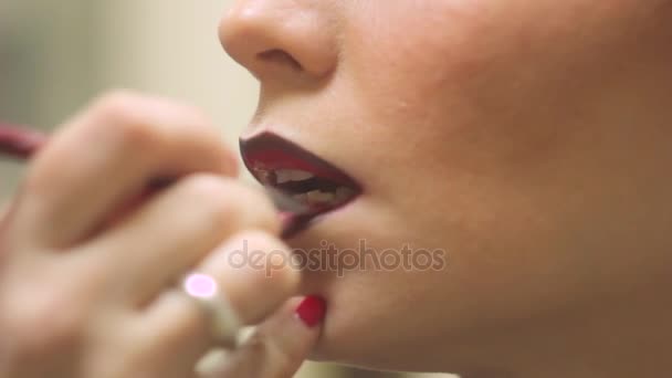 Maquillaje artista pinta sus labios mujeres — Vídeo de stock