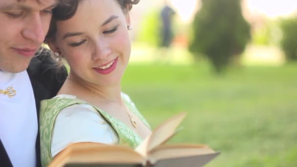 Casal lendo um livro ao ar livre — Vídeo de Stock