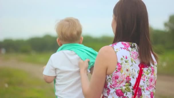 Anya és a gyermek ül a fűben — Stock videók