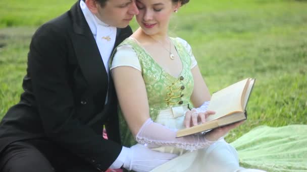 Couple reading a book outdoors — Stock Video