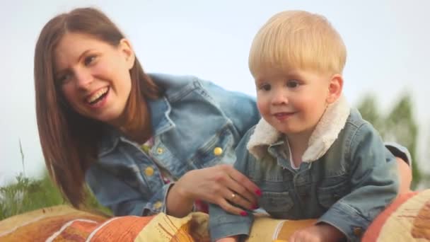Мати і дитина сидять на траві — стокове відео