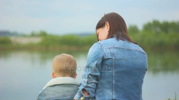 Moeder en kind zitten op het gras — Stockvideo