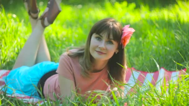 Die Frau liegt auf dem Gras — Stockvideo