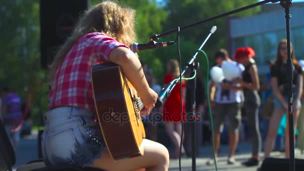 Rusia, Novokuznetsk - 27 de junio de 2017: Chica tocando la guitarra en la calle — Vídeo de stock