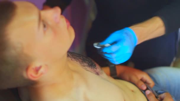 Татуировщик делает татуировку. — стоковое видео