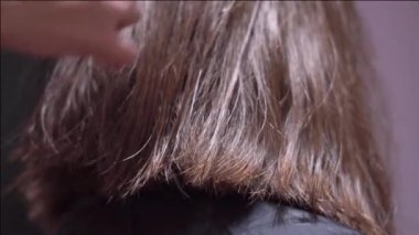 bir kadın saçlarını makasla kesmek