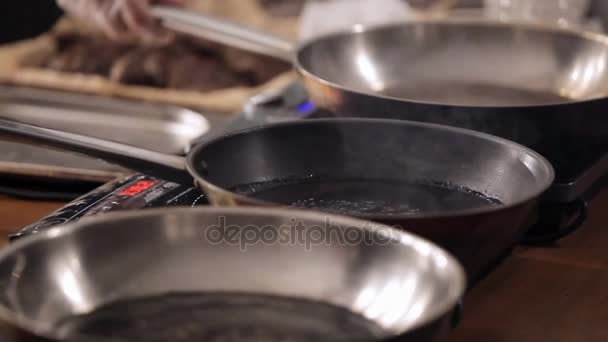 調理する前にウォーム アップする待っている鍋を調理します。人は、フライパンは加熱しているかどうかをチェックします。 — ストック動画