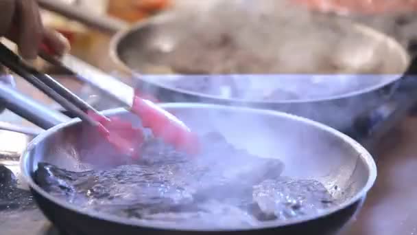 Fechar as mãos dos cozinheiros. Fechar as mãos dos cozinheiros. Mãos masculinas. O homem remexe em volta da carne em uma panela de ato de fritar. O homem derruba pedaços de carne em uma frigideira quente . — Vídeo de Stock