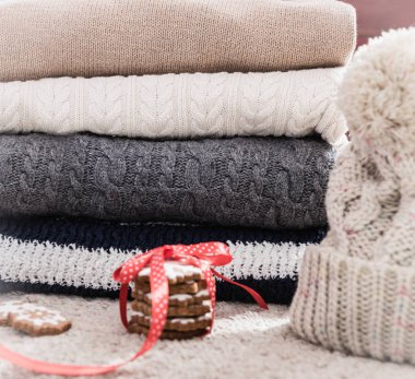 Kış giysileri örgü yığını: kazak ve hafif bir arka plan üzerine şapka