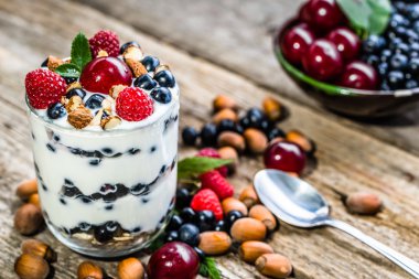 Soğuk yoğurt dondurma berry meyve ve fındık tatlı, yaz sağlıklı kahvaltı kavramı donmuş bir cam bardak ile