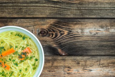 Tavuk suyu çorbası erişte üzerinde ahşap bir masa, üstten görünüm