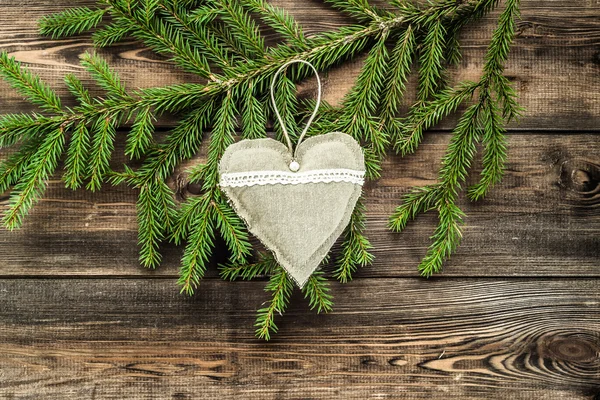 Textile pillows in shape heart. Decoration hanging on christmas tree branch.