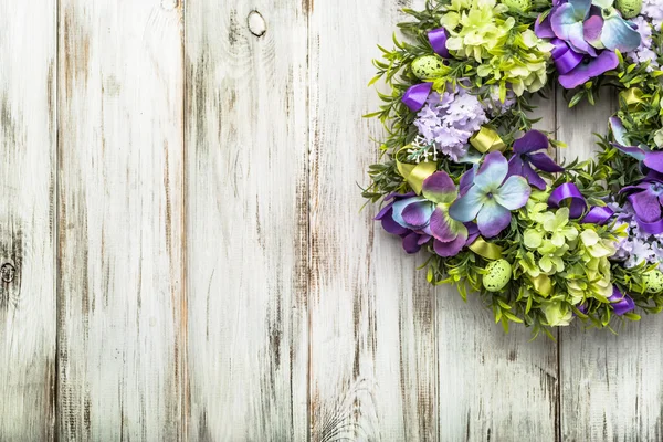 Couronne de Pâques de printemps avec œufs, buis et fleurs sur fond de bois blanc . — Photo