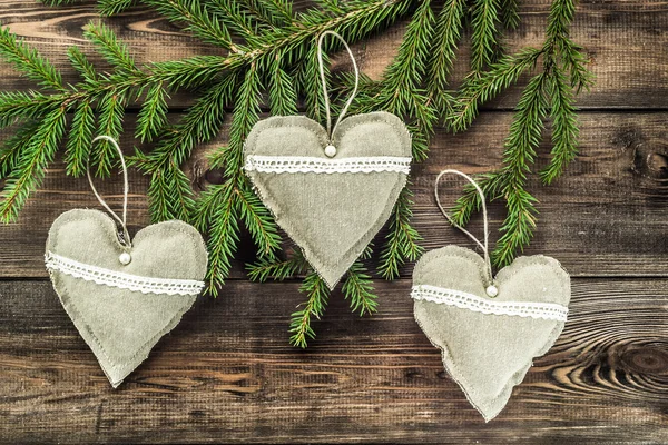 Travesseiros decorativos têxteis em forma de coração pendurado no ramo da árvore de natal — Fotografia de Stock