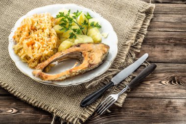 Kızarmış balık, patates ve lahana turşusu rustik zemin üzerine haşlanmış. Geleneksel Lehçe akşam yemeği.