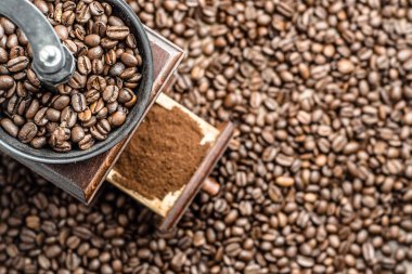 El ile kahve değirmeni ile kavrulmuş kahve çekirdekleri, üstten görünüm