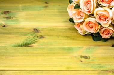 ahşap masa üstünde pembe gül buketi