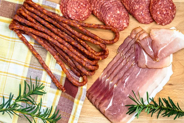 Sortimento de carnes: kabanos, fatias de prosciutto de salame em madeira — Fotografia de Stock