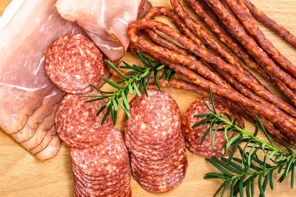 Választék a húsok: kabanos, szalámi sonka szeletek a fa — Stock Fotó
