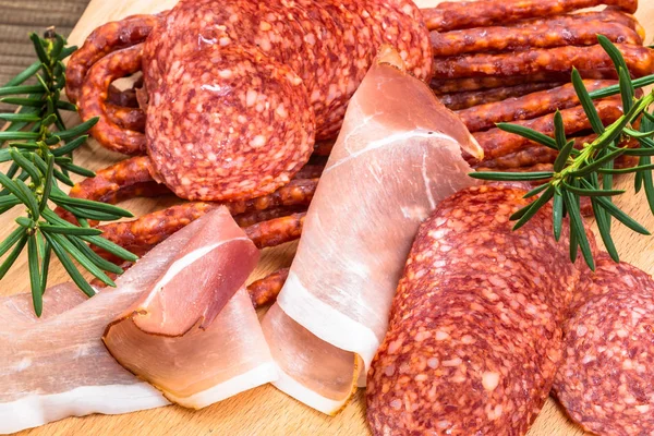 Surtido de carnes: kabanos, rebanadas de jamón salami sobre madera — Foto de Stock