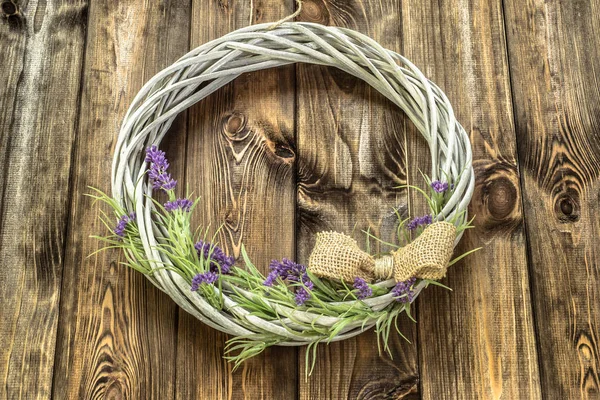 Couronne en osier avec des fleurs de lavande sur fond en bois. Style provençal . — Photo