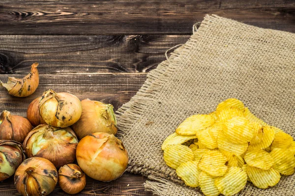 Куча картофельных чипсов, аромат лука на деревенском фоне — стоковое фото