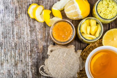 Bir bardak çay, ahşap masa üzerinde ek yükü. Sıcak çay limon, zencefil bir tatlım. Soğuk algınlığı ve grip için yapılmış çare ev.