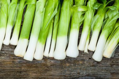 Taze pırasa, yeşil sebzeler, ahşap rustik masada çiftlik taze ürün görünümü top