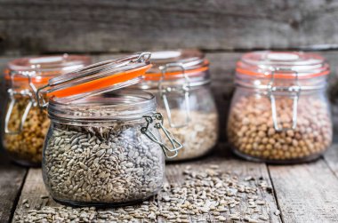 Ahşap masa, sağlıklı beslenme, vegan gıda kavramı rustik kavanoza soyulmuş ayçiçeği tohumu