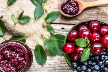 Rustik kavanoz vişne ve taze kiraz bir kase ile yukarıdan görüntülemek