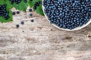 Sepeti ahşap masa üzerinde ormandaki çiftçi üzerinde olgunlaşmış meyve taze bilberries Pazar, yukarıdan