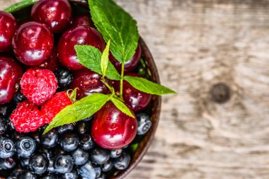 Ahşap çiftlik tablo, sağlıklı beslenme, superfood kavramı üzerinde ek yükü bir kabın içinde çeşitli meyve