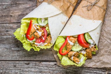Bükülmüş lezzetli tortilla buritos rulo, doldurulmuş ızgara tavuk ve sebze, lokanta, Meksika mutfağı ile sandviç