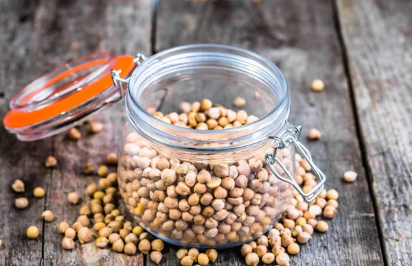 Pois chiches crus dans un bocal rustique sur une table en bois, saine alimentation, concept alimentaire végétalien — Photo