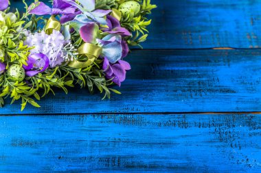 Paskalya çelenk ile Paskalya yumurtaları ve çiçekler, Bahar ev dekor ahşap arka plan üzerinde