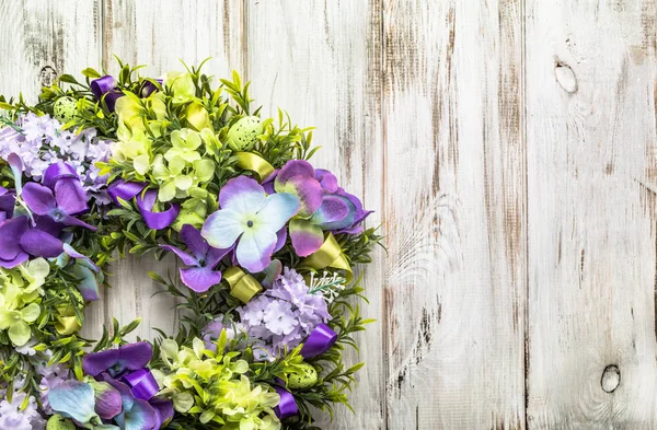 Couronne de Pâques avec des œufs et des fleurs de Pâques, décor de printemps à la maison sur fond en bois — Photo