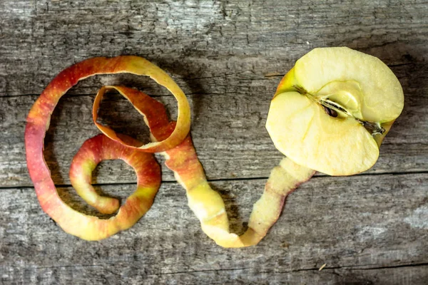 Demi-pomme avec écorce pelée sur table en bois, section transversale, vue de dessus — Photo