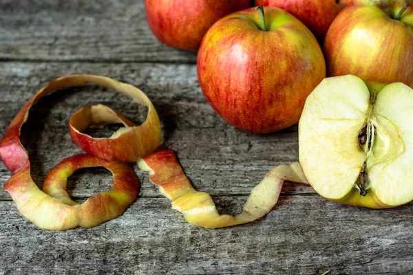 Pommes entières et coupées en deux sur fond en bois — Photo