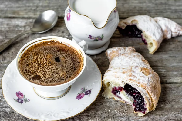 Delicioso postre - croissant con mermelada y taza de café en la mesa de madera — Foto de Stock